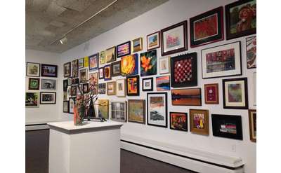 A variety of colorful and unique paintings and artworks on a wall