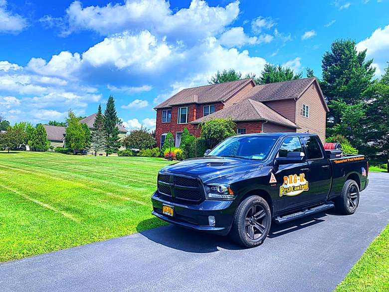 black truck in a driveway with a house in the background