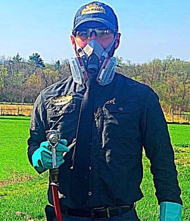man with protective mask and pest control hose
