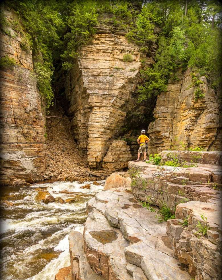 man stands before cliffs