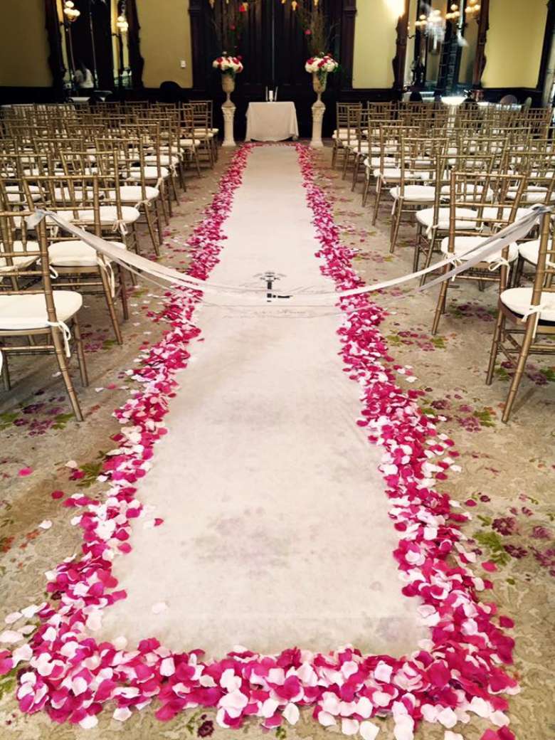 White carpet walkway with flowers lining the exterior
