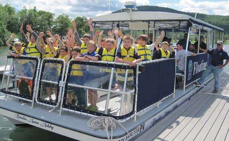 A group of kids in yellow life jackets on a boat