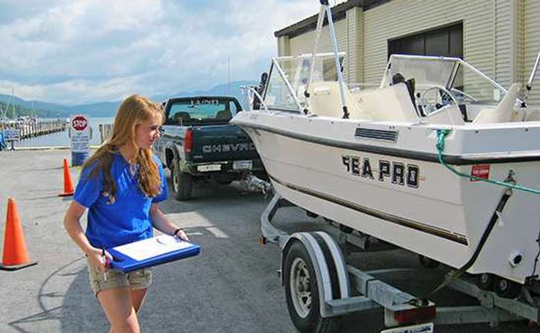 A young woman inspecting a boat before it can be launched into Lake George