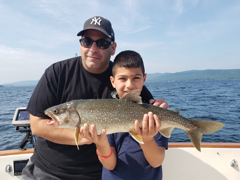 man and child holding fish