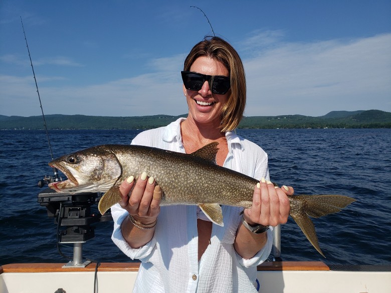 woman in white shirt holding fish