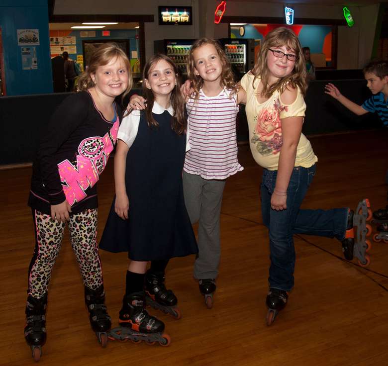 four girls posing in their roller blades