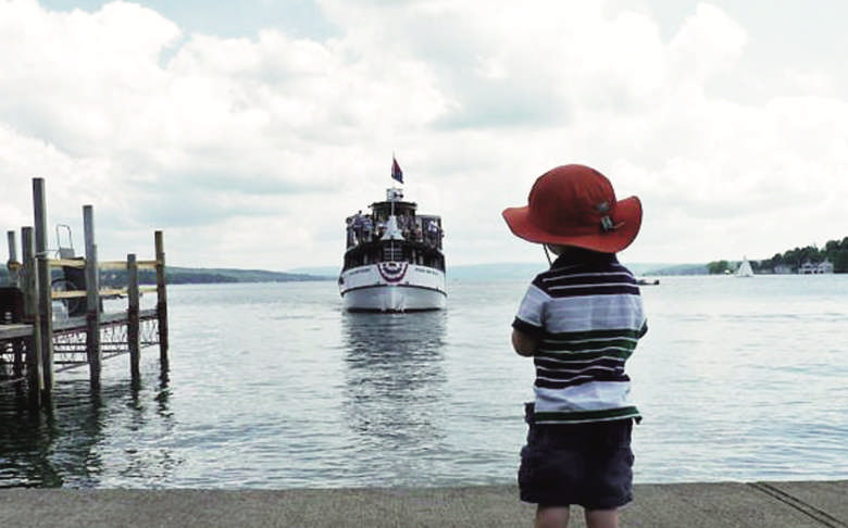 Boy watching boat at Skaneateles Lake