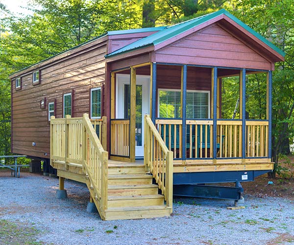 cabin in the woods with a porch and stairs in the front