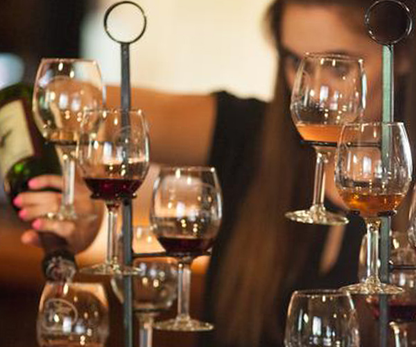 woman pouring flight of wine at saratoga winery