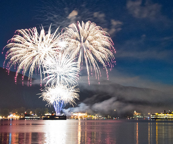 fireworks over lake george with steamboats lit up