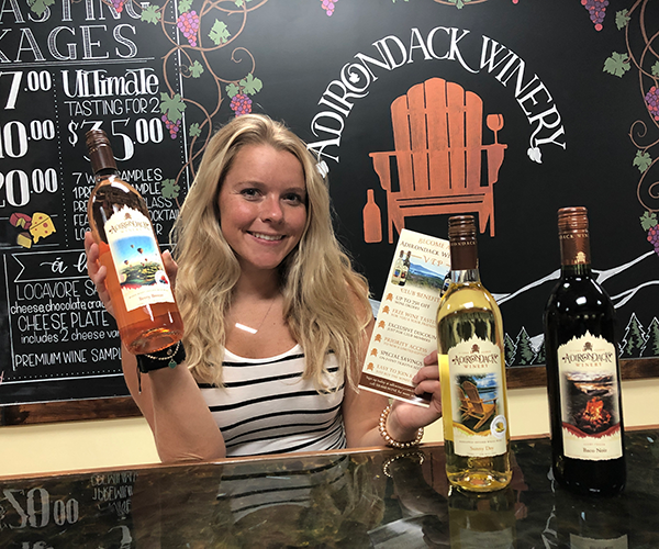 woman holding a bottle of Adirondack winery wine