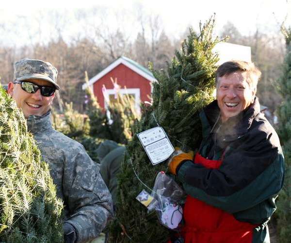 troops holding Christmas trees at Ellms Family Farms