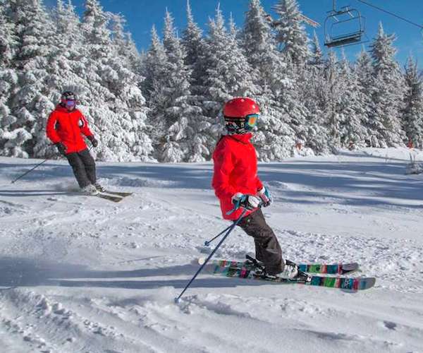 two people in red jackets skiing down Gore mountain