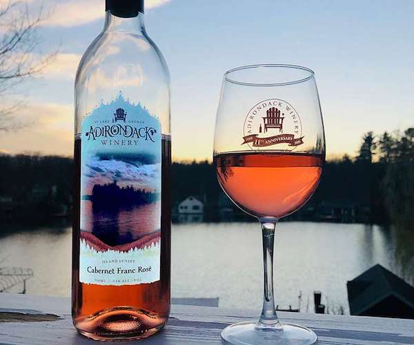 image of wine glass and wine bottle with Adirondack Winery branding