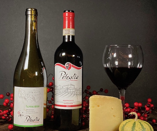 two bottles of Peteglia wine and a wheel of cheese