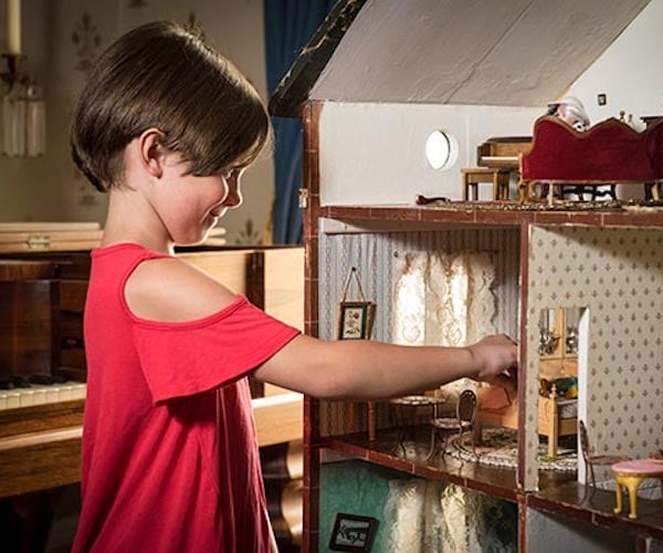 girl playing with a doll house