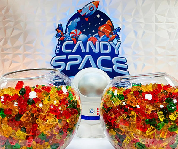 two bowls of gummy bears and the candy space logo