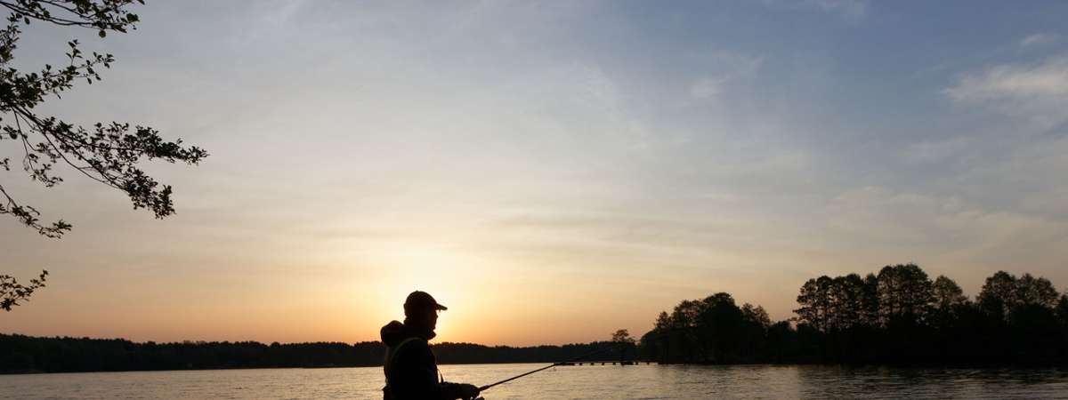 man fishes at sunrise