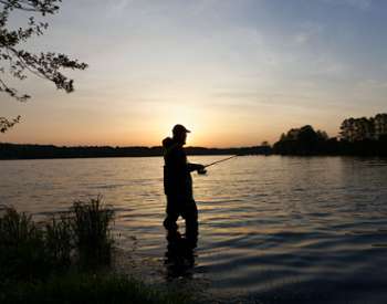 man fishes at sunrise