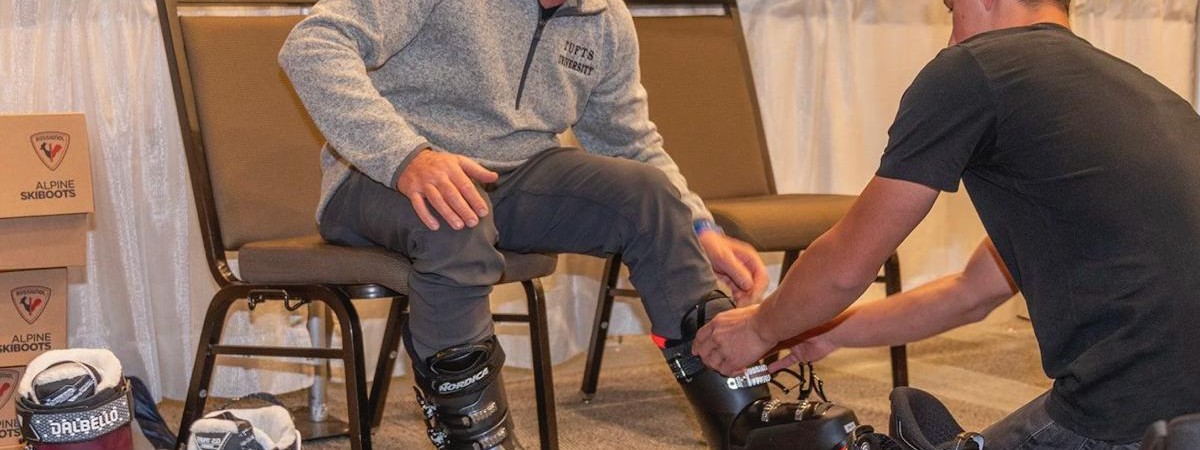 guy getting help with ski boots