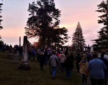 people walking in a graveyard at twilight