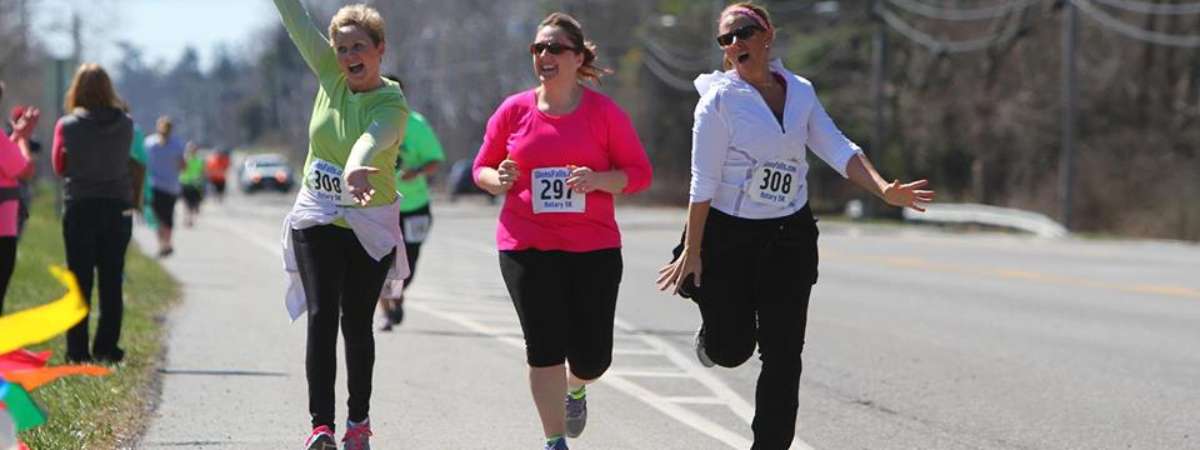 three women running together in a race