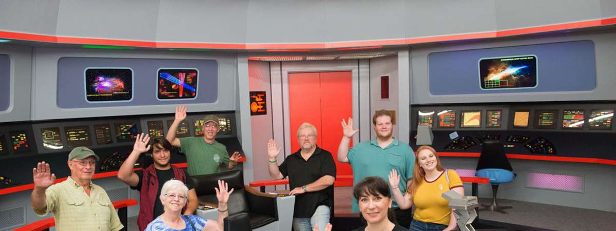 a group of star trek fans in a recreated Star Trek Enterprise control room