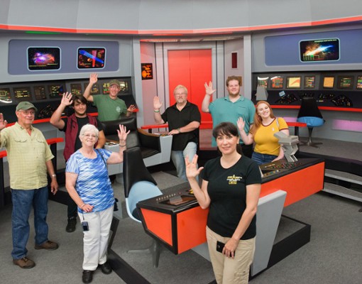 a group of star trek fans in a recreated Star Trek Enterprise control room