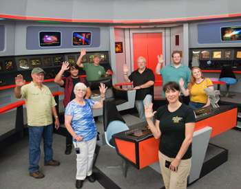 a group of star trek fans in a recreated Star Trek Enterprise control room