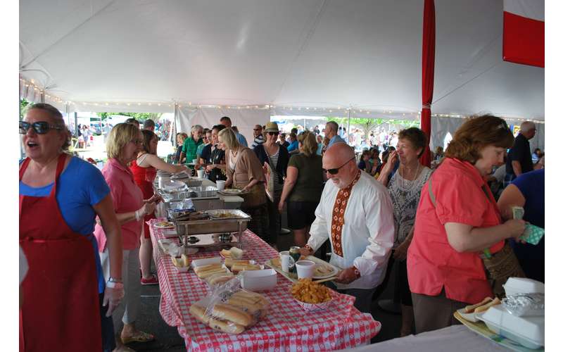 crowd of people getting food at serving tables