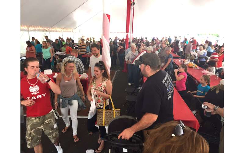 a crowd of people at a festival under a big tent