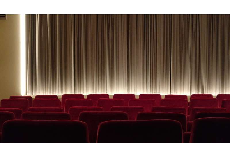 red theater seats near curtain on stage