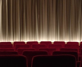 red theater seats near curtain on stage