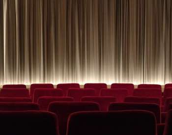 red theater seats near curtain on stage