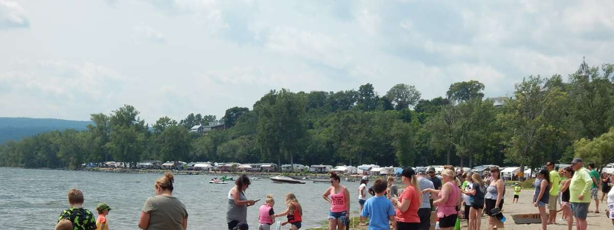 people on beach with cardboard boats