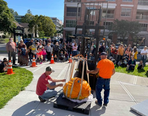 people at a big pumpkin weigh in