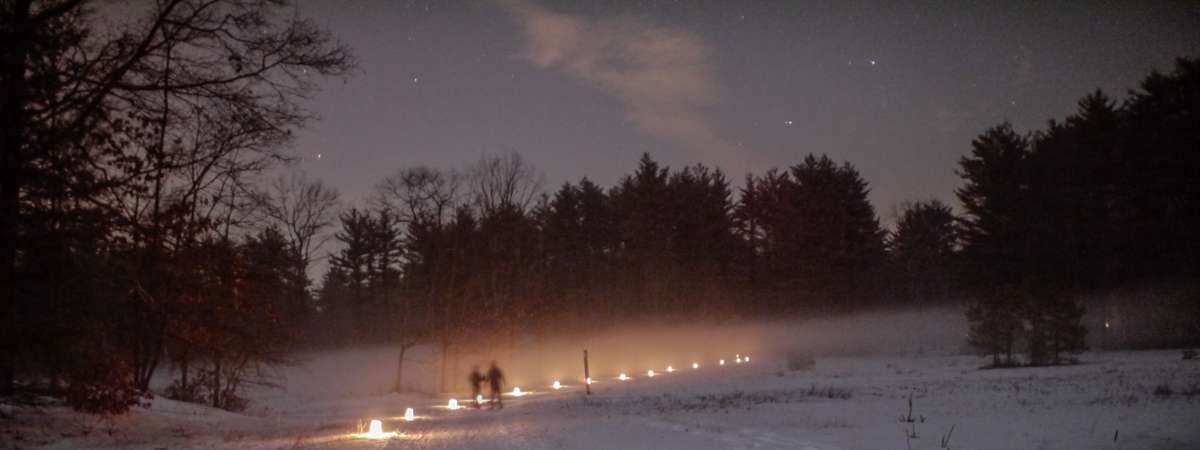 candles along trail at night in winter