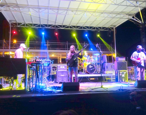 a band performing on stage with colorful lights