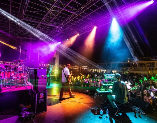 band playing onstage under colorful lights