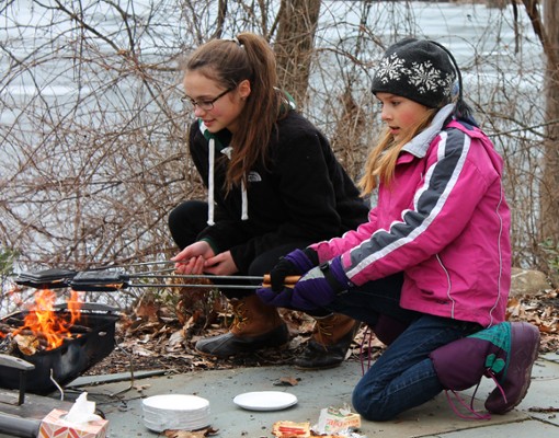 two girls roasting s'mores