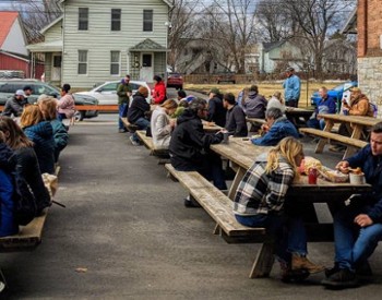 people eating at picnic tables outdoors