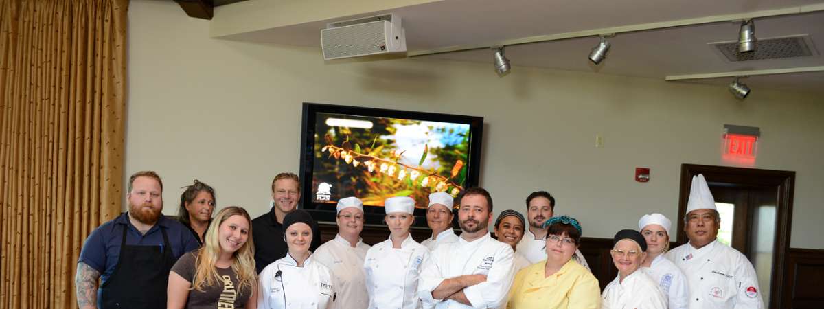 a group of people and chefs posing for a photo