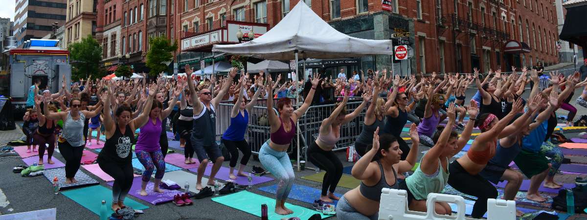 people doing yoga outdoors on a city street