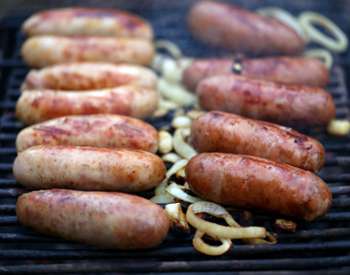 brats and onions on a grill
