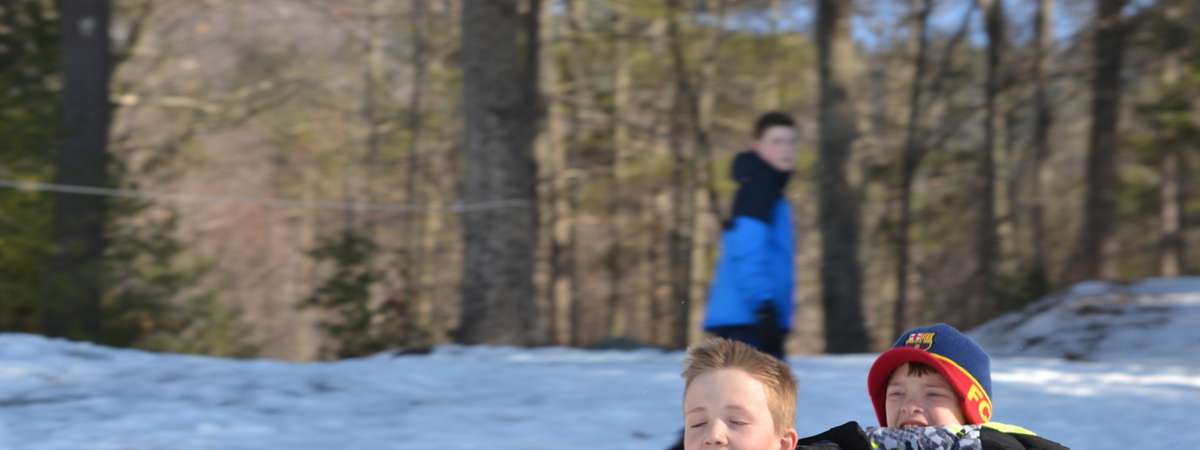 two little boys snow tubing