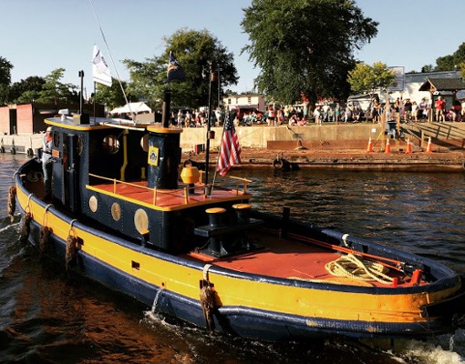 a large tugboat with yellow, blue, and orange colors