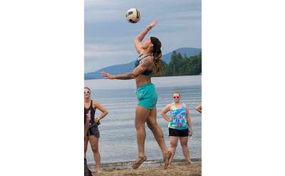 woman hitting volleyball on beach