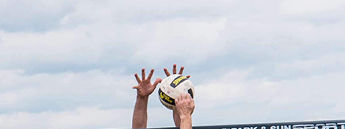 player hitting volleyball over net