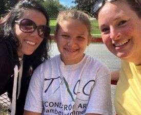 two women and young girl pose together