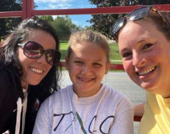 two women and young girl pose together